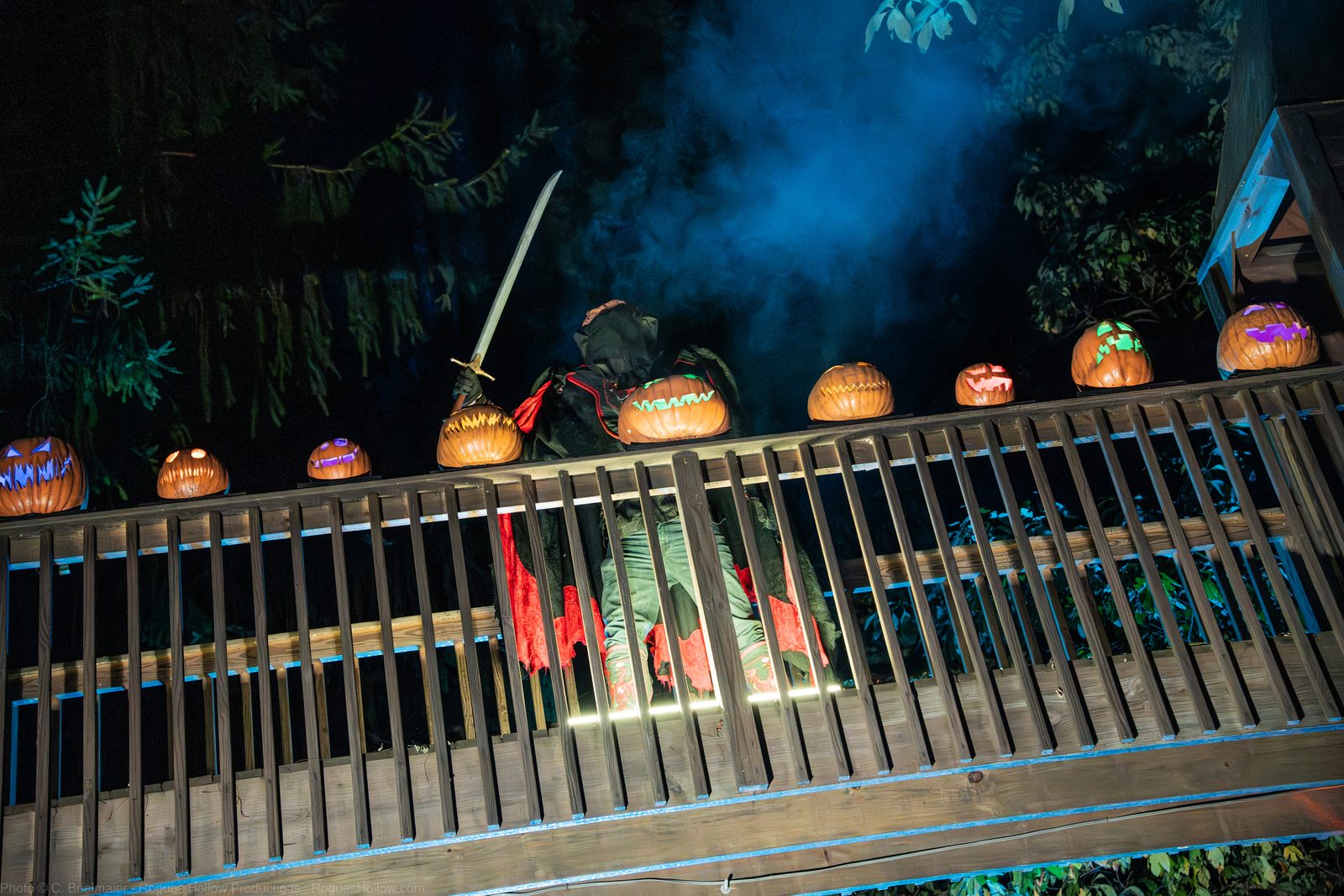 The Headless Horseman crossing a bridge lined with carved jack-o'-lanterns at night